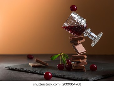 Cherry liqueur in a glass with chocolate and cherries. Balancing concept.