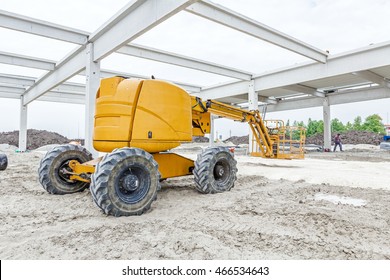 Cherry Picker Is Parked Below Concrete Skeleton Of New Assembled Building Frame.