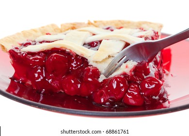 A cherry pie closeup cut into with a fork. Shot on white.