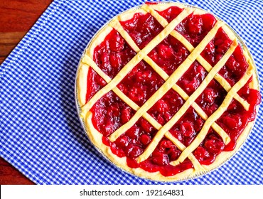 Cherry Pie. Fresh homemade cherry pie on blue and white gingham background. 