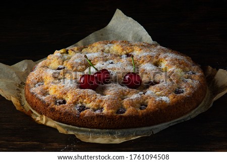 Cherry pie on an old dark wooden table.