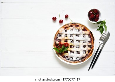 Cherry pie on a white wooden background with place for text. Tart with a cherry. View from above. Layout