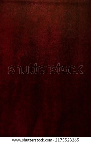 Cherry red brown leather texture. Bible leather cover background. Old deep crimson colored leather. Light top, darker bottom.