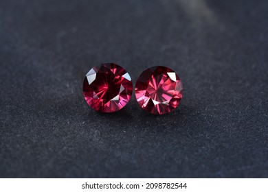 Cherry red color genuine rhodolite or almandine garnet loose round gemstones matched pair. Si clarity, unheated, untreated. Stone settings for making earrings jewelry. Dark gray background. Gemology.