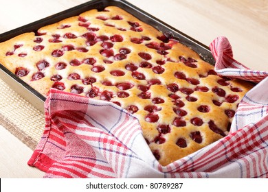 Cherry Sponge Cake After Baking In Tin With Towel