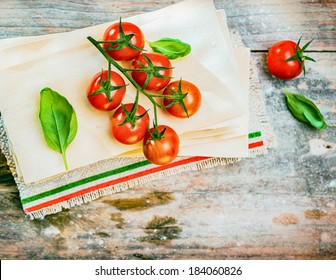 Cherry Tomatoes, Basil And Dried Lasagne Sheets On An Old Weathered Wooden Table In A Rustic Kitchen Ready To Be Used As Ingredients For An Italian Pasta Dish, View From Above