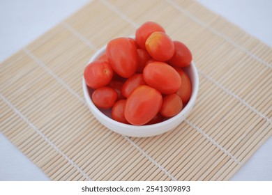 cherry tomatoes in a bowl on a bamboo mat - Powered by Shutterstock