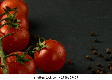                                Cherry tomatoes on a black stone table. Image can be used as a texture as well. Some pepper on the right side.   