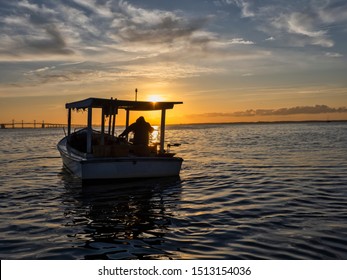 A Chesapeake Bay Waterman Out At Dawn In A Traditional Wooden Crab Boat.