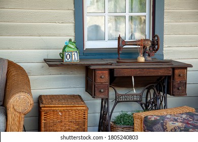 Chesapeake City, MD 08/25/2020: Close Up Image Of A Rusty Antique Hand Crank Singer Sewing Machine Placed On The Porch Of An Old House.