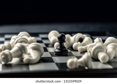 Chess board. Black pawn among the defeated white chess of the opponent. Horizontal frame