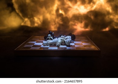 Chess Board Game Concept Of Business Ideas And Competition Or War Theme. Chess Figures On A Dark Background Of Explosion And Fire Clouds. Selective Focus