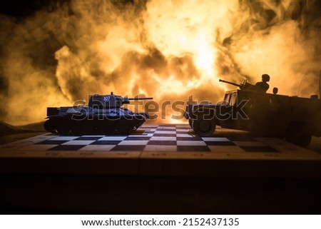 Chess board game concept of business ideas and competition or war theme. Chess figures on a dark background of explosion and fire clouds. Selective focus
