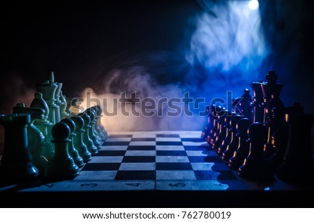 Chess board game concept of business ideas and competition and strategy ideas concep. Chess figures on a dark background with smoke and fog. Selective focus