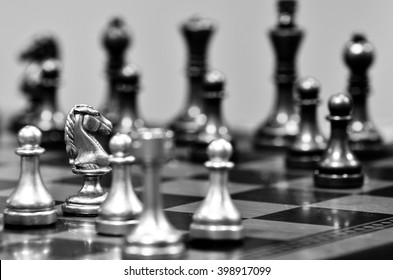 Chess board with white knight facing opponent in match
