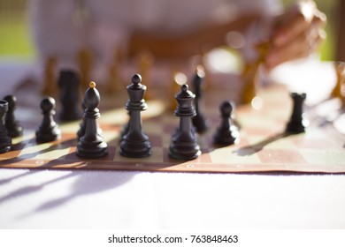 Chess figures and player in background.