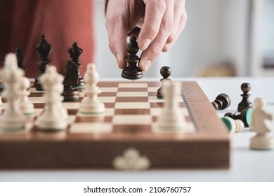 Chess game, hand moves black bishop across the chessboard. Male businessman plays chess in office. Business strategy, tactics concept. Wooden chess board, pawns, knights, rooks, bishops, queen, king
 - Shutterstock ID 2106760757