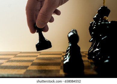 Chess game player makes a move the black pawn  forward on neutral background