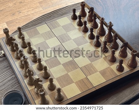 A chess game with two groups of pieces on a brown board