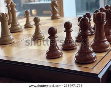 A chess game with two groups of pieces on a brown board