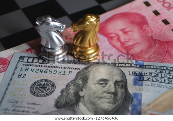 Chess game,\
two knights face to face on Chinese yuan and US dollar background.\
Trade way concept. Conflict between two big countries, USA and\
China concept. Copy space for\
text.