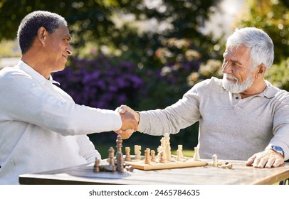 Chess, handshake and men winning, success or thank you for congratulations with friends at park outdoor. Play board game, shaking hands and senior people at garden for strategy, victory and welcome - Powered by Shutterstock