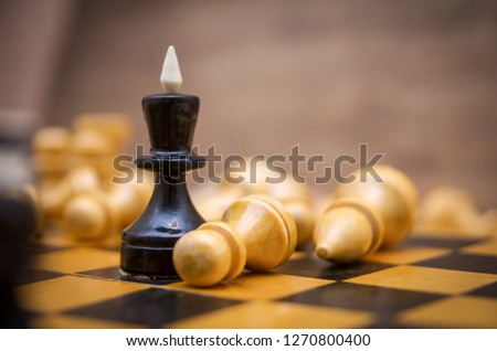 Chess leadership concept with gold and black chess, queen surrounded by pawns