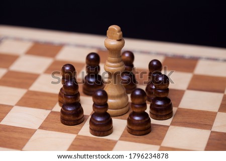 Chess, many against one, the concept of teamwork. Black pawns surrounded the white Queen