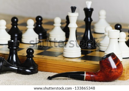 Chess middle game and tobacco pipe of one of the players