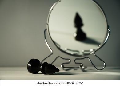 A chess piece is reflected in the mirror. Things and people are not what they seem. Reassessment of their abilities. Psychology, motivation. Power of thought. Never give up, always go for your goal. - Shutterstock ID 1850958751