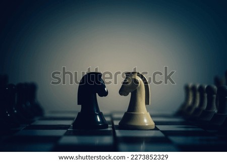 Chess pieces knights facing each other for a standoff on a chessboard, the concept of two leaders who oppose each other, Chess knights head to head.