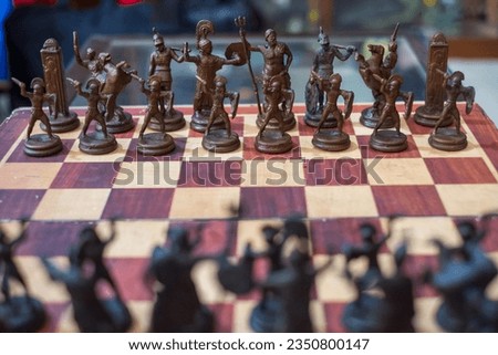 chess pieces made based on greek mythology are on a chessboard