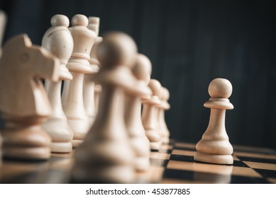 Chess pieces on the board. Black wood background behind.