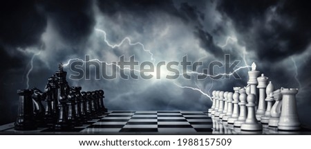 Chess pieces on a chessboard against the background of a dark stormy sky. Game of chess as symbol of strategy, leadership and business victories. Concept on the topic of struggle, clashes in politics.