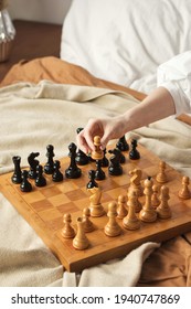 Chess Player Woman Learns Chess Opening By Playing With Himself. White Pawn One Step Forward. Chess Wooden Board With Chess Pieces On Light Background. Strategy Board Game Played. Closeup Toned Photo