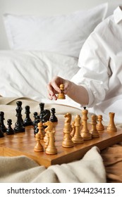 Chess Player Woman Learns Chess Opening By Playing With Himself. White Pawn One Step Forward. Chess Wooden Board With Chess Pieces On Light Background. Strategy Board Game Played. Closeup Toned Photo