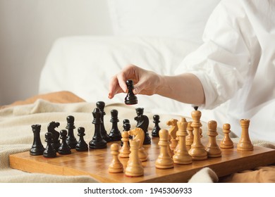 Chess Player Woman Learns Chess Opening By Playing With Himself. Black Pawn One Step Forward. Chess Wooden Board With Chess Pieces On Light Background. Strategy Board Game Played. Closeup