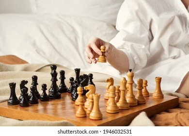 Chess Player Woman Learns Chess Opening By Playing With Himself. White Pawn One Step Forward. Chess Wooden Board With Chess Pieces On Light Background. Strategy Board Game Played. Closeup Toned Photo