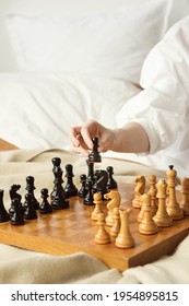 Chess Player Woman Learns Chess Opening By Playing With Himself. Black Pawn One Step Forward. Chess Wooden Board With Chess Pieces On Light Background. Strategy Board Game Played. Closeup 