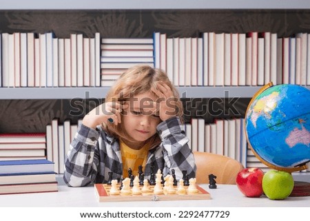 Chess school for kids. Clever child thinking about chess. Portrait of clever kid with chessboard. Boy play chess.