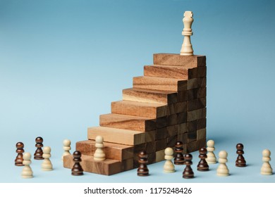 Chess standing on a pyramid of wooden building blocks. career ladder concept, Business hierarchy with copy space.