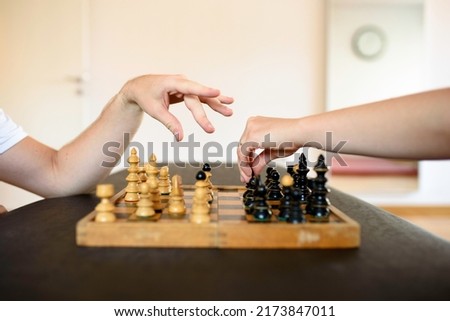 Chess table and two hands preparing for the move. A game of outwitting.
Wisdom, right move, intelligence, cognitive therapy, out thinking, competition concepts.
