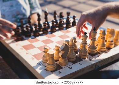 Chess tournament, kids and adults participate in chess match game outdoors in a summer sunny day, players of all ages play, competition in chess school club with chessboards on a table