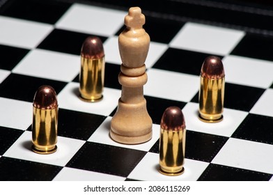 Chessboard king surrounded by gun bullets pawn pieces .45 calibre ACP
