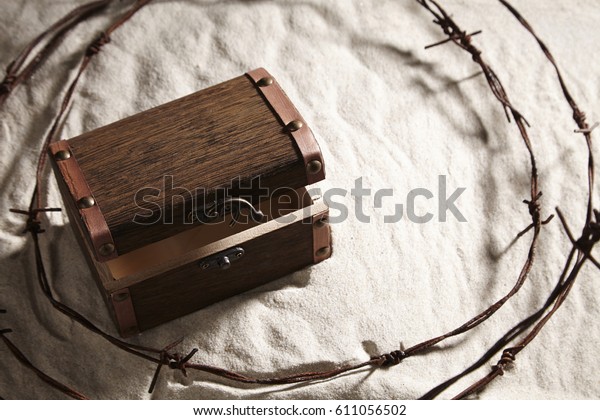 chest box on
top of sand surrounded by barb
wire
