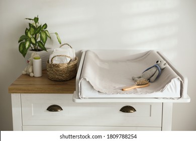 Chest of drawers with changing pad and tray in nursery. Baby room interior design - Powered by Shutterstock