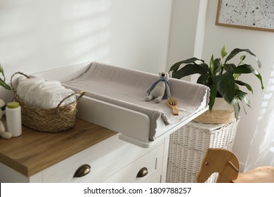 Chest of drawers with changing pad and tray in nursery. Baby room interior design - Powered by Shutterstock