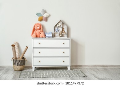 Chest of drawers with clothes and toys in children's room