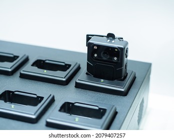 Chest video recorder. Fragment of station for charging DVRs. Video recorder on light background. Concept is police chest video recorder. Device for recording police actions. DVRs devise sale