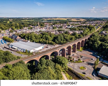 CHESTER LE STREET, COUNTY DURHAM, UK - CIRCA JULY 2017: Aerial view of a railway viaduct running past a Tesco grocery store in a small English town